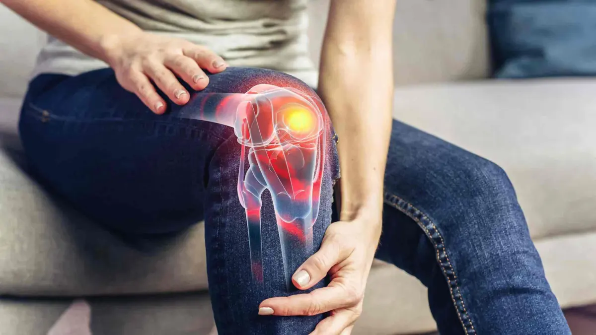 Knee pain clinic in Reading — Mr Sam Nahas Woman holding her knee in pain, close-up of the knee